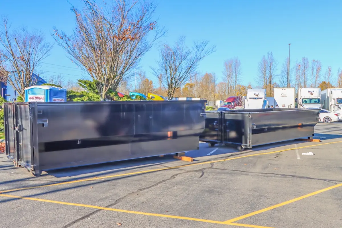 Professional dumpster rental service with roll-off container on residential driveway in Amherst